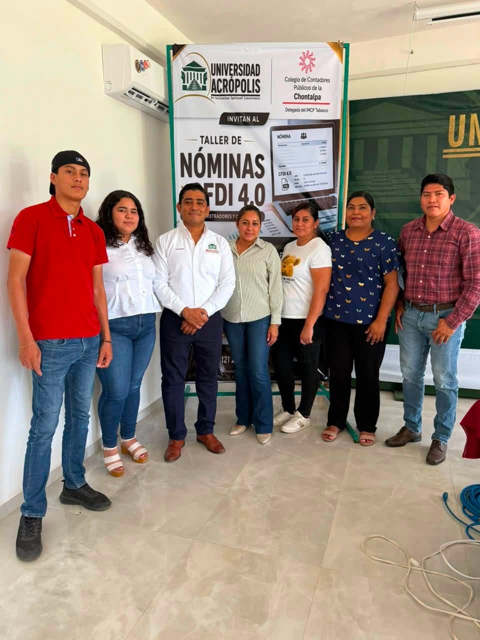 Siete participantes posan frente al cartel del Taller de Nóminas y CFDI 4.0.